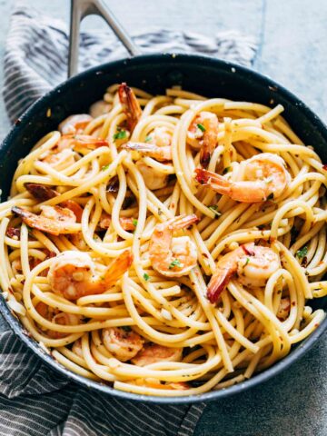Shrimp Spaghetti Aglio Olio garnished with parsley, parmesan and served in a bowl.