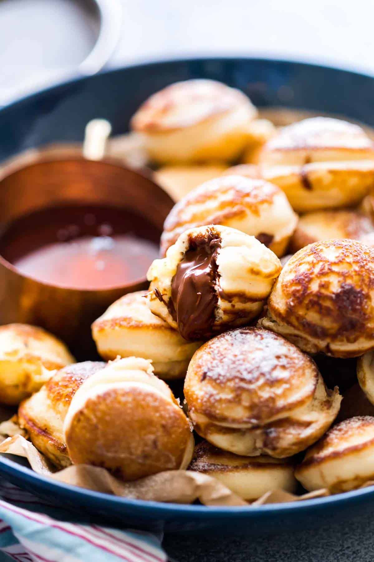 Chocolate Stuffed Mini Pancake Bites served with maple syrup on the side.