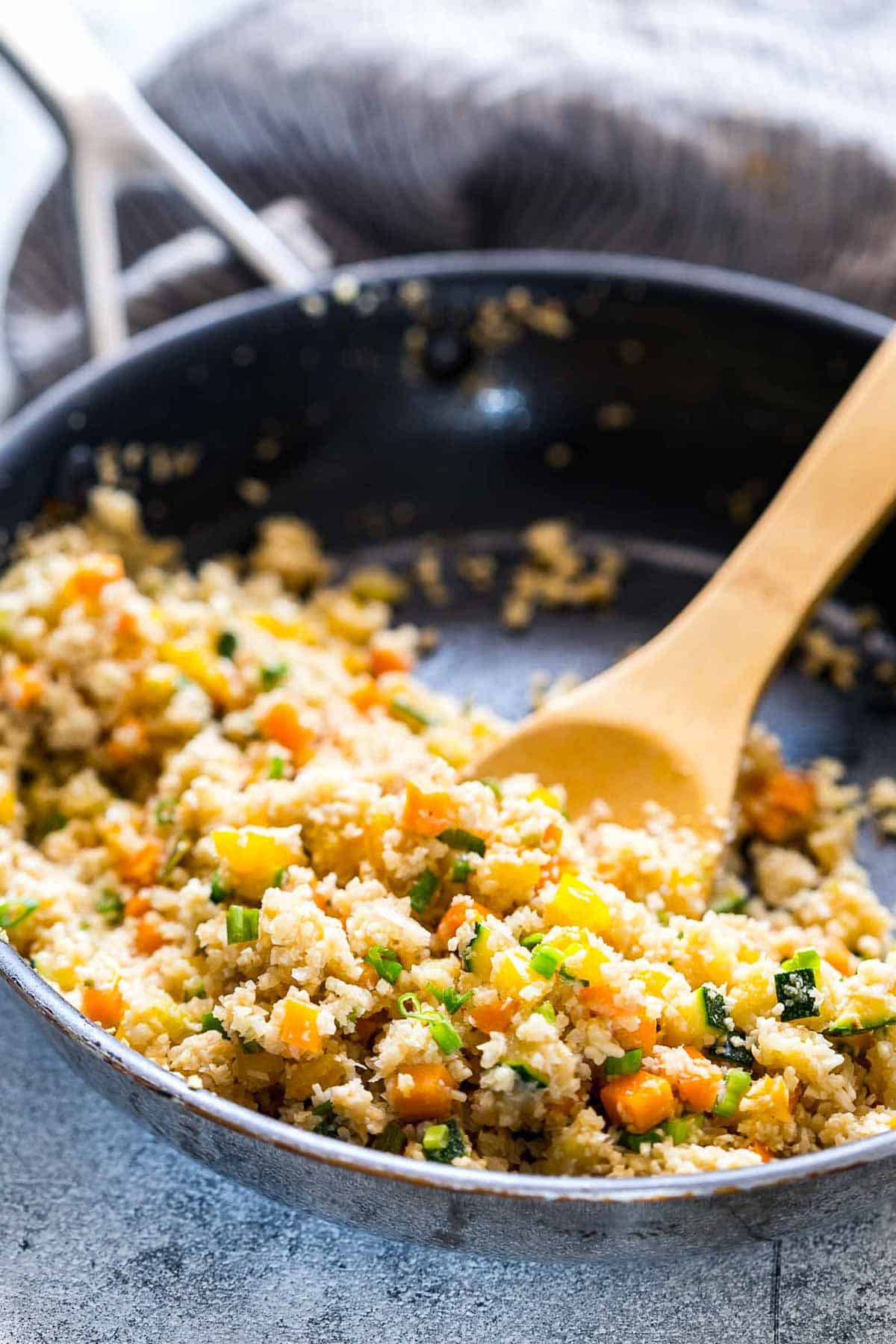 Low Carb Asian Cauliflower Rice being tossed in a pan.