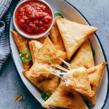 Super cheesy jalapeno three cheese samosa are sure to become a favourite because who can resist gooey stringy cheese stuffed in crispy samosa wrappers! These vegetarian samosas have a filling of mozzarella, cream cheese, smoked cheddar and jalapenos and folding them is really easy too. 
