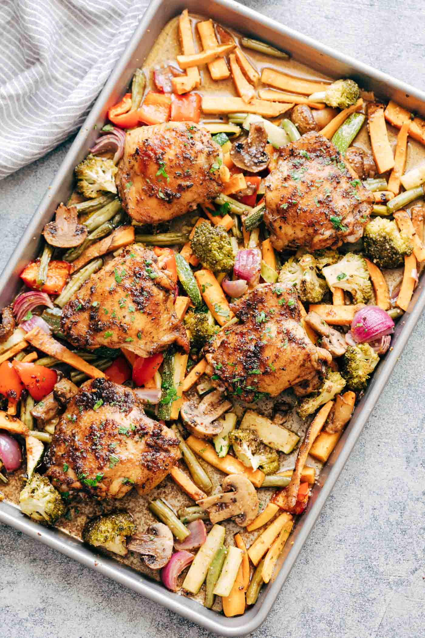 Sheet Pan Honey Balsamic Chicken Thighs with Veggies tray with broccoli, peppers, onions, sweet potatoes, carrots, mushrooms and broccoli
