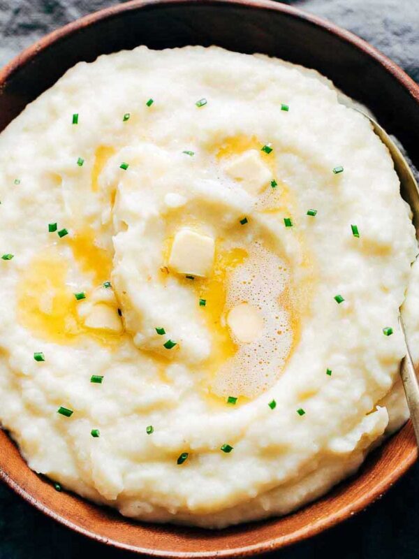 picture of garlic mashed potatoes served in a brown bowl with a spoon on the side