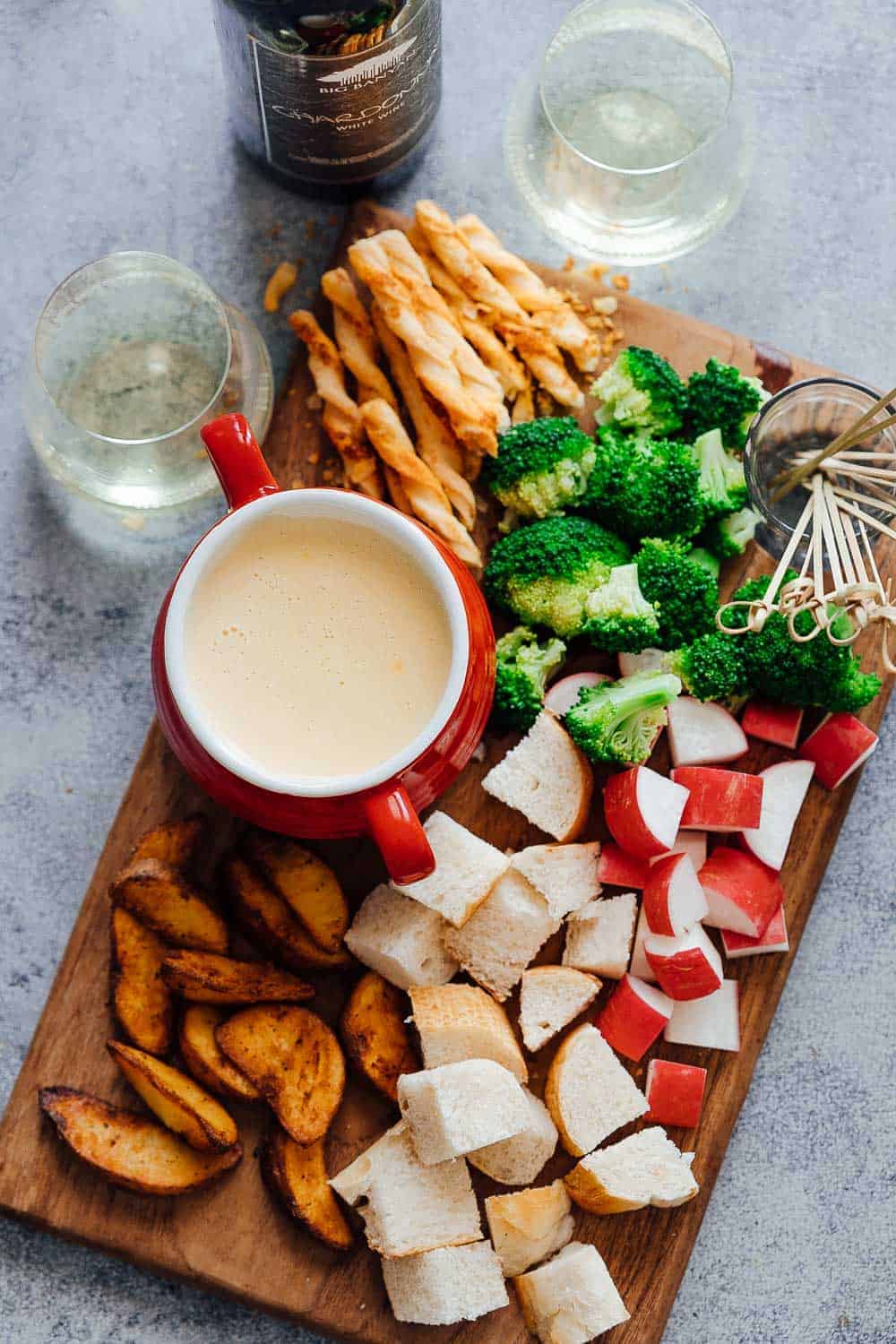Easy cheese fondue recipe with white wine picture with fondue dippers such as bread, broccoli, wedges, radishes, bread sticks etc.