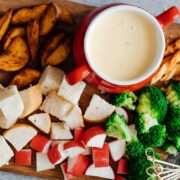 Easy cheese fondue recipe with white wine picture with fondue dippers such as bread, broccoli, wedges, radishes, specie sticks etc.