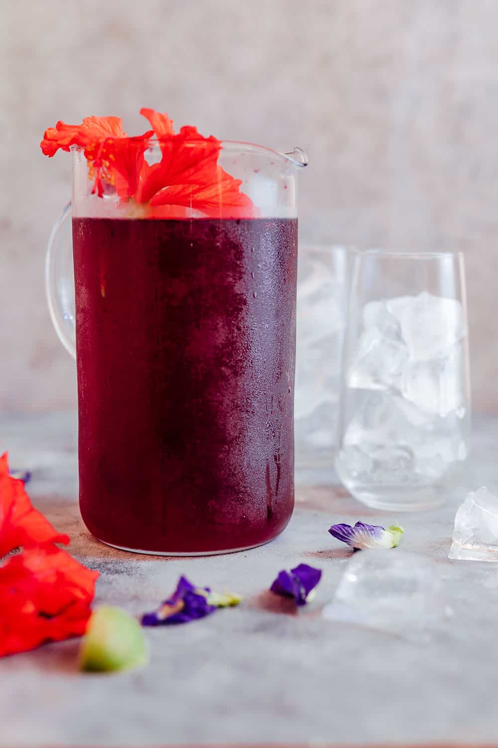 Iced Hibiscus Tea served in a large jug with fresh hibuscus flowers