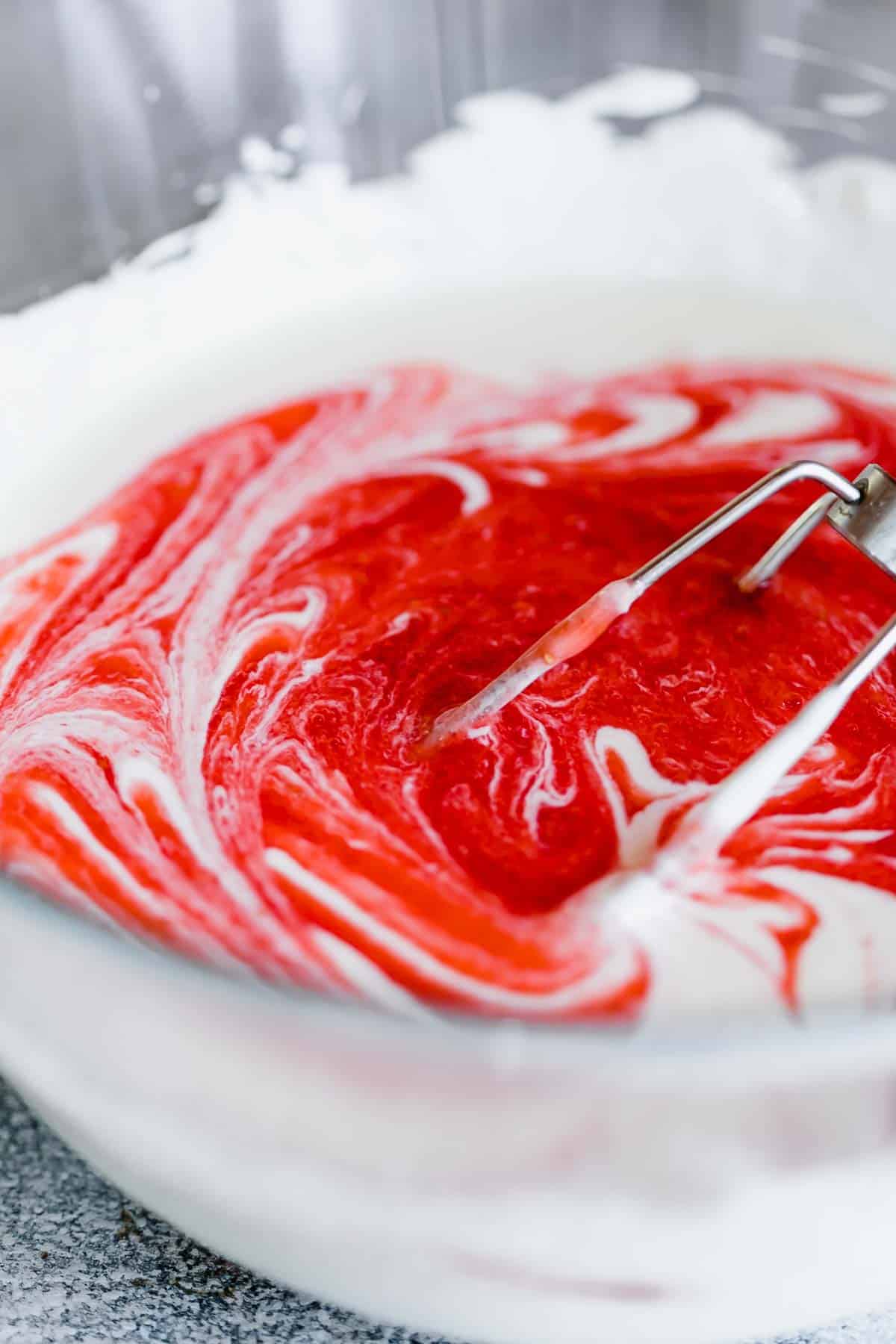 strawberry cheesecake batter swirled with strawberry puree in a bowl