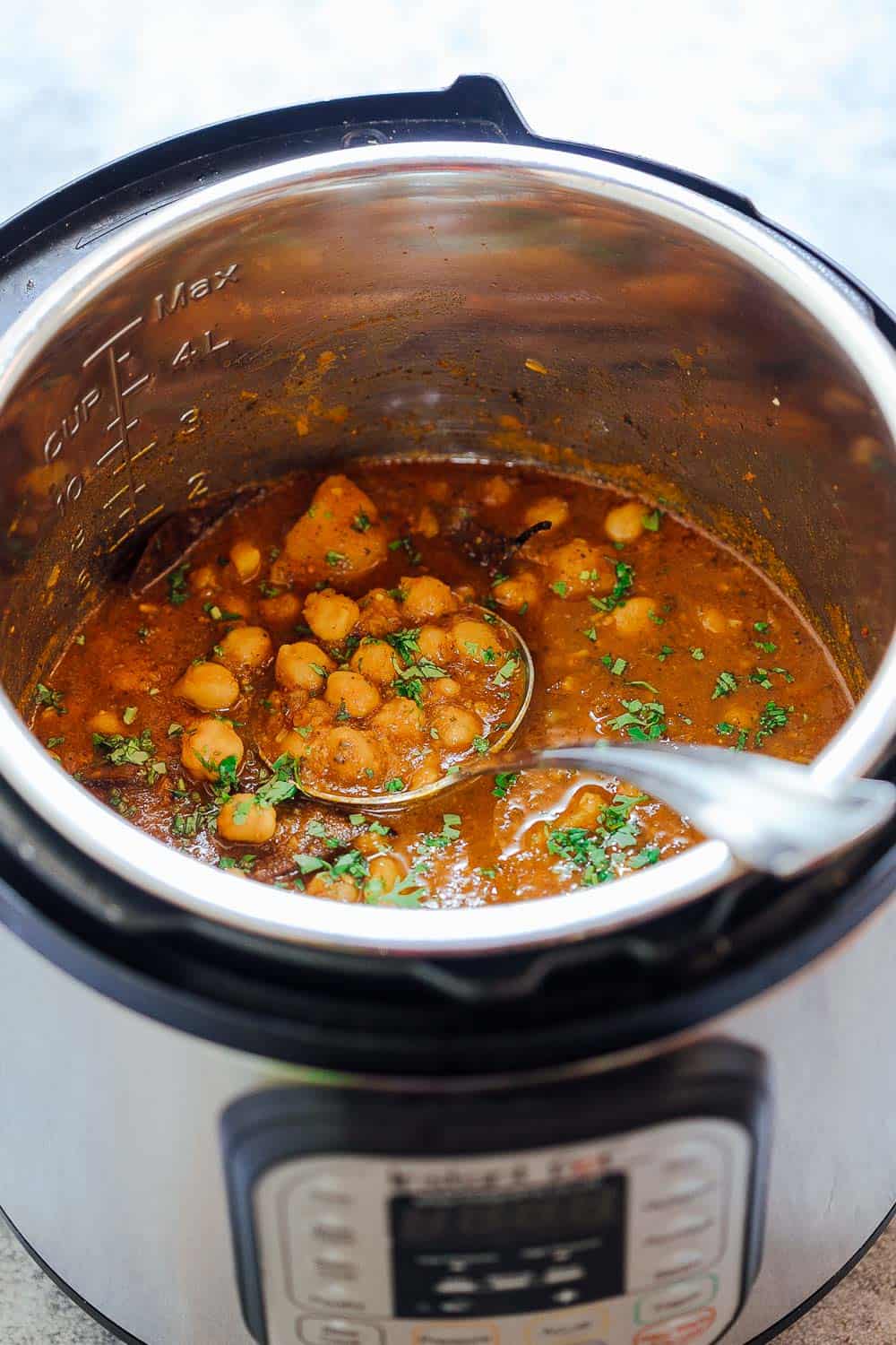 Pressure cooker chana masala in an Instant Pot with a steel ladle