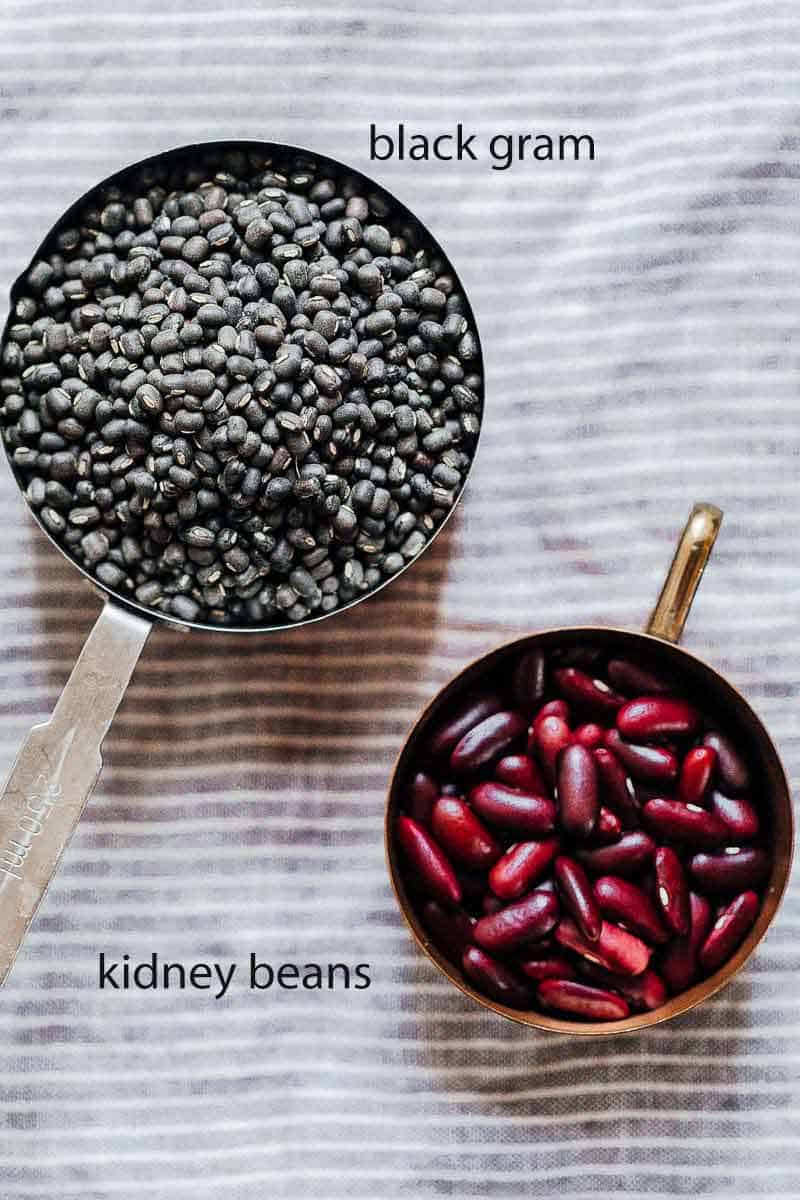 Black gram (urad dal) and kidney beans (rajma) in measuring cups - two lentils for dal makhani