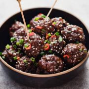 Sticky Thai Meatballs served in a black bowl with toothpicks.