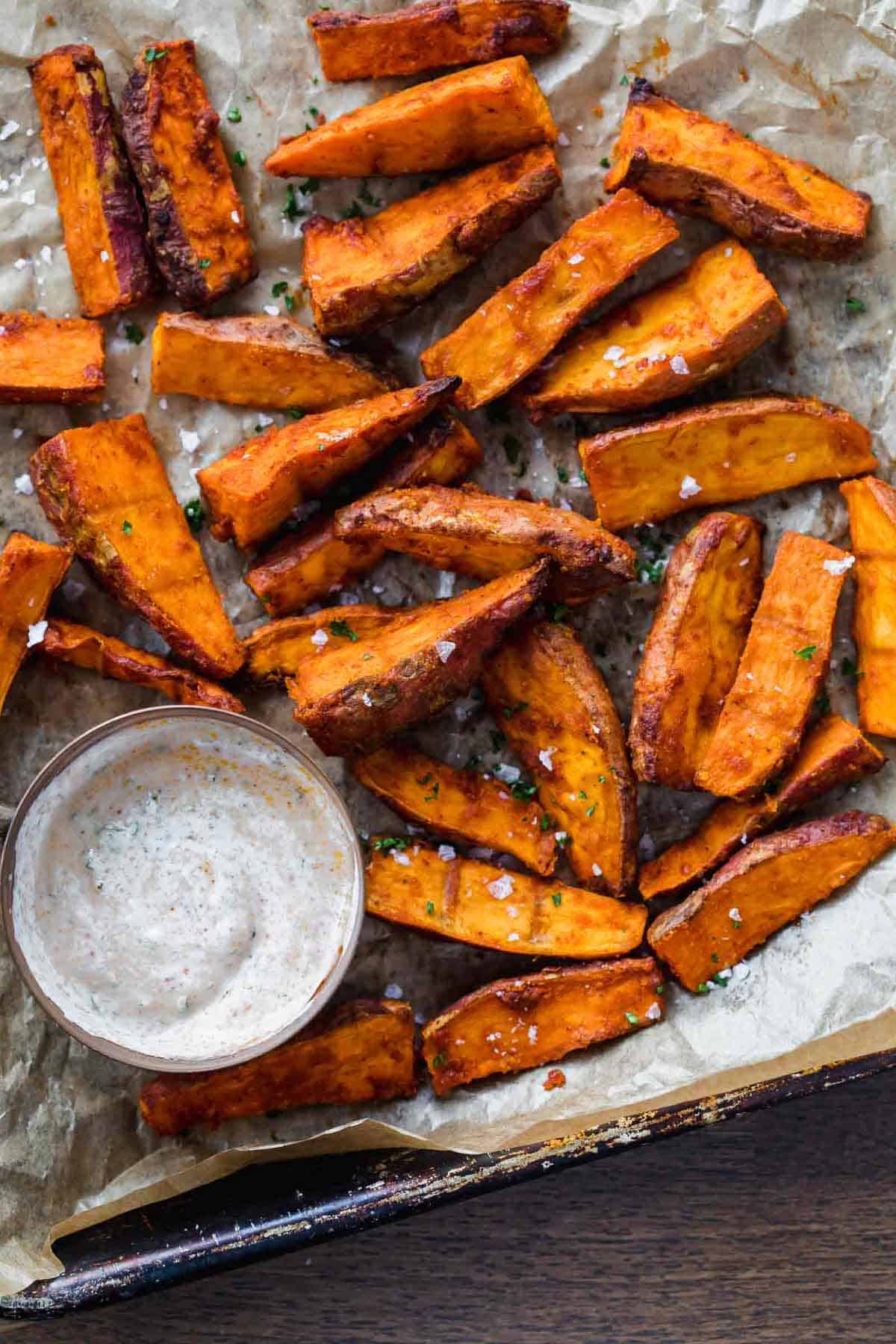 Chilli Lime Sweet Potato Wedges baked and served on a tray with a dipping sauce