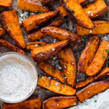 Chilli Lime Sweet Potato Wedges baked and served on a tray with a dipping sauce.