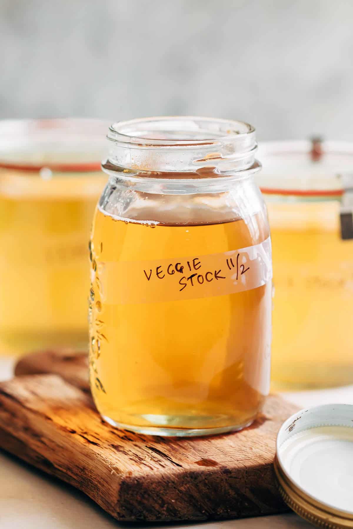 Homemade vegetable stock strained into a canning jar