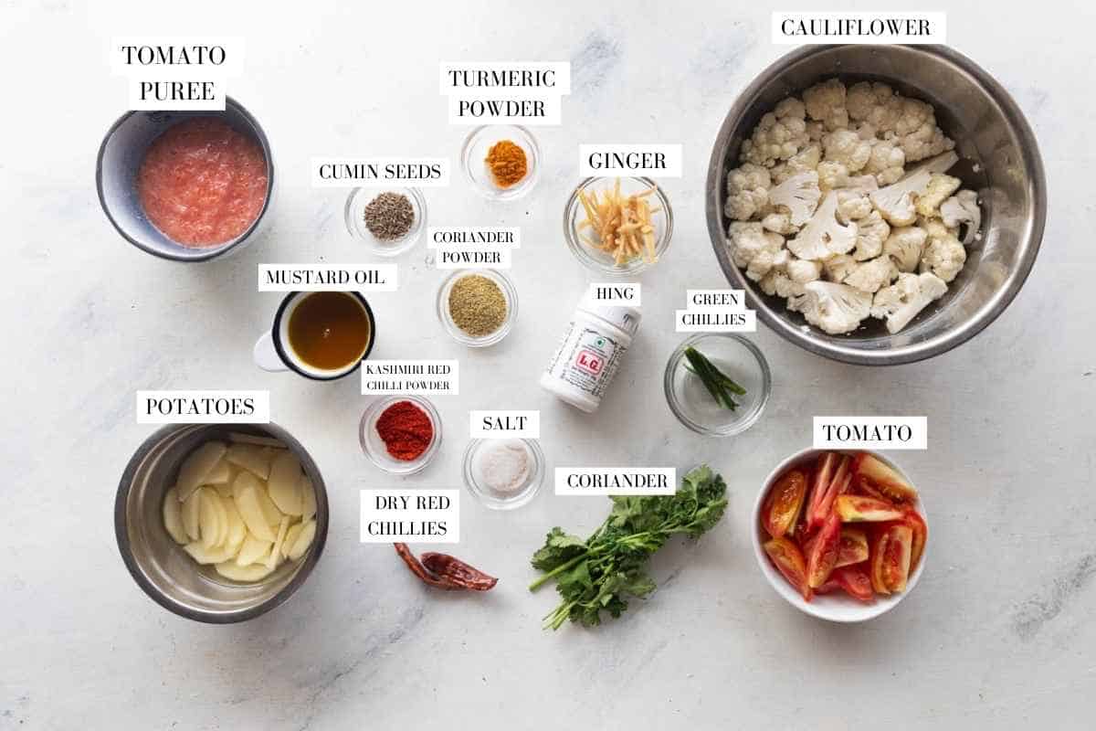 Picture of all the ingredients for aloo gobi masala with text to identify them