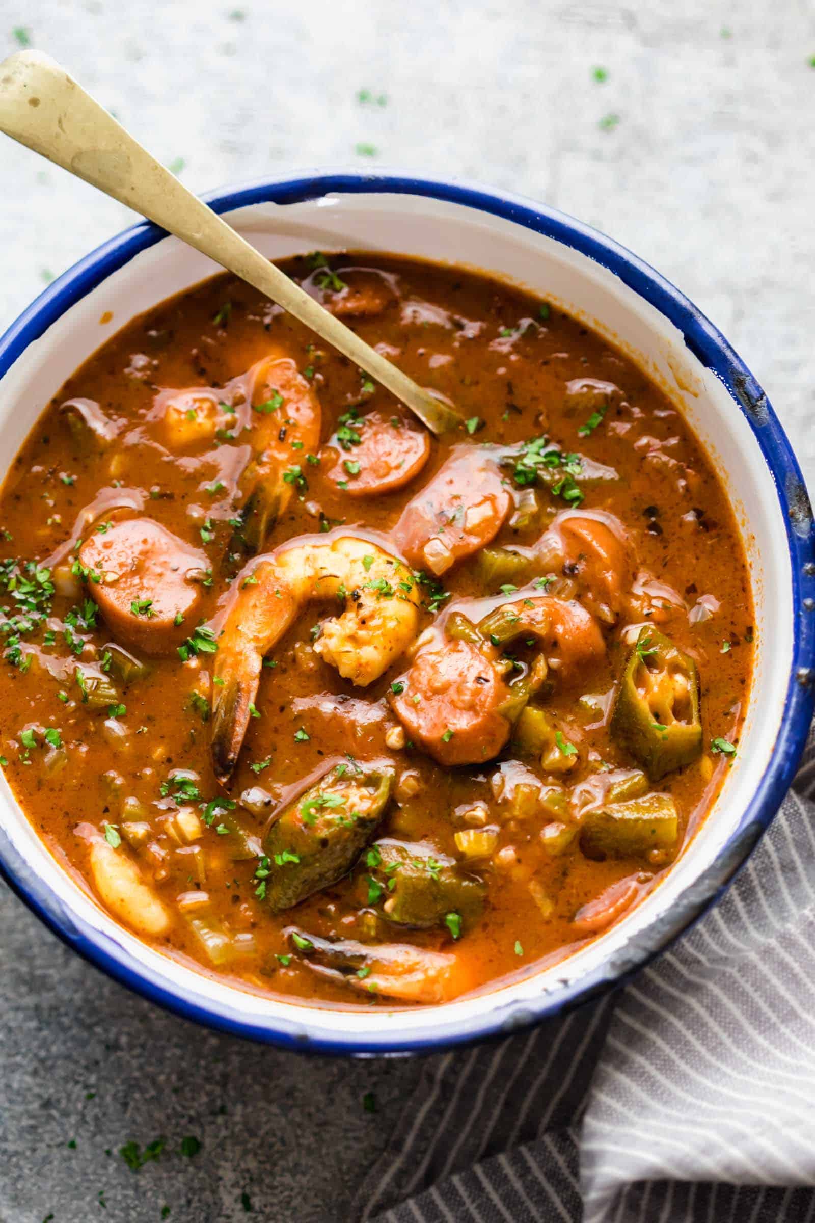 New Orleans Shrimp Sausage Gumbo served in an enamel bowl with a spoon