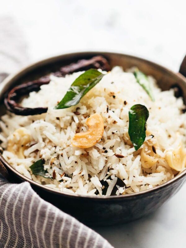Coconut rice served in a kadhai topped with roasted cashews and curry leaves