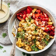 Curried roasted cauliflower bowl with tahini dressing drizzled on top