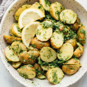 Healthy Lemon Dill Potato Salad (no mayo) served in a white speckled trencher with lemon wedges