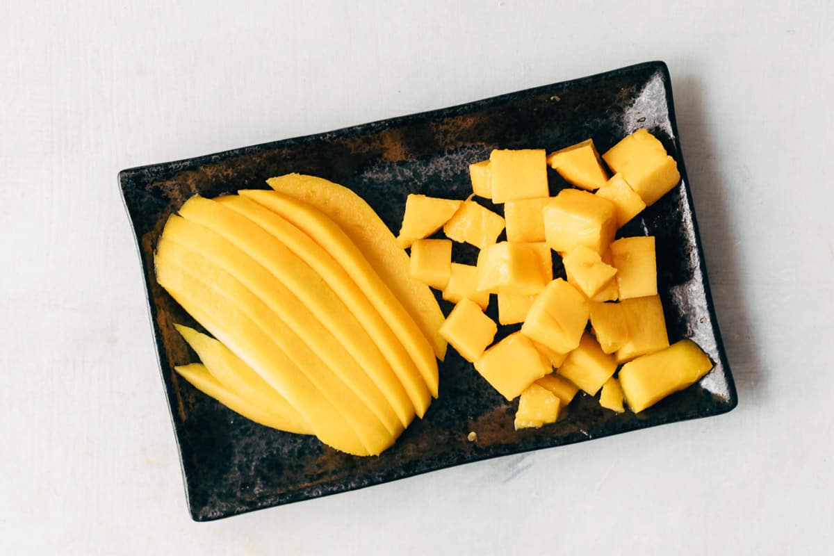 A peeled mango cut into really thin wedges and dices.