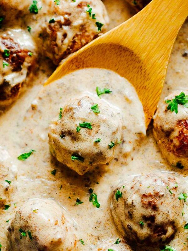 Creamy Chicken Meatballs in Mushroom Sauce with a wooden ladle.