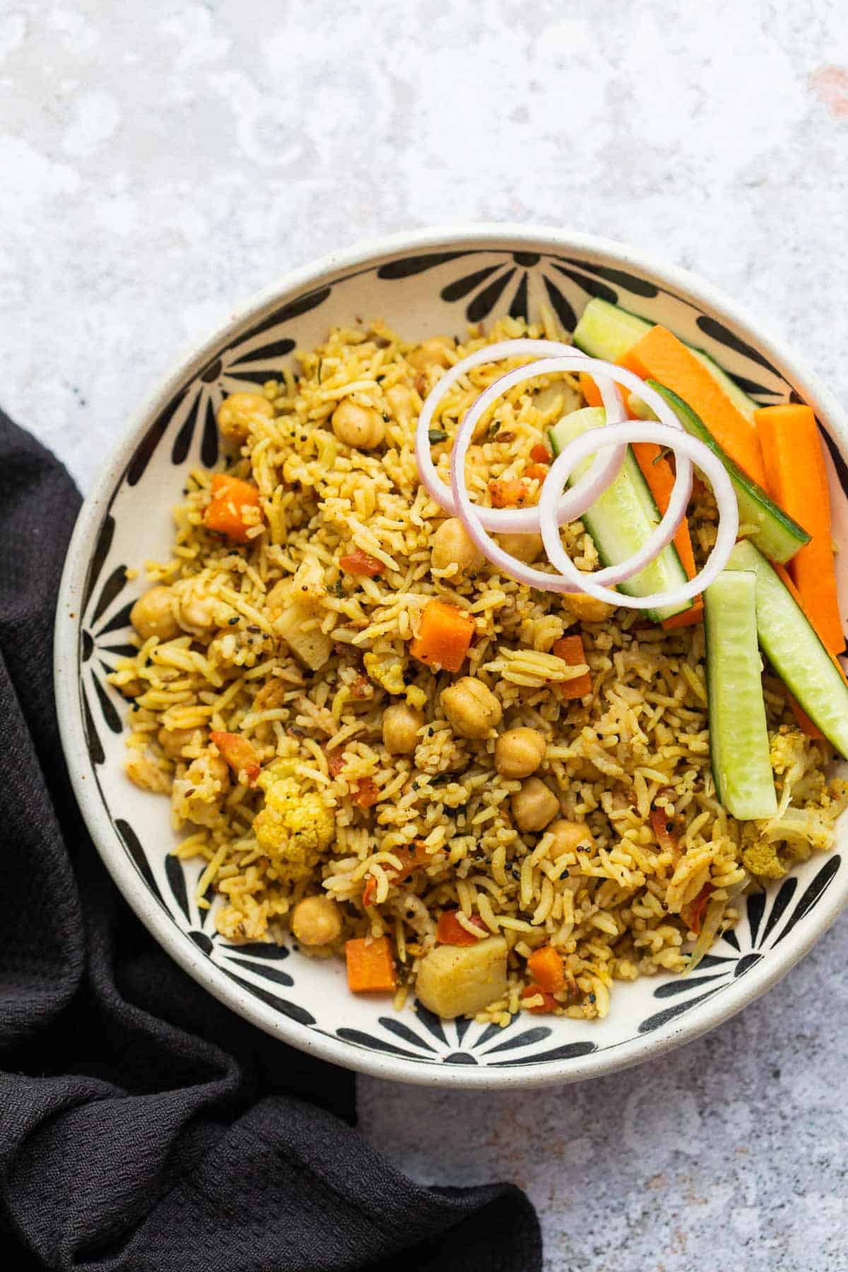 Kabuli Chana Pulao served in a bowl with onions and a salad
