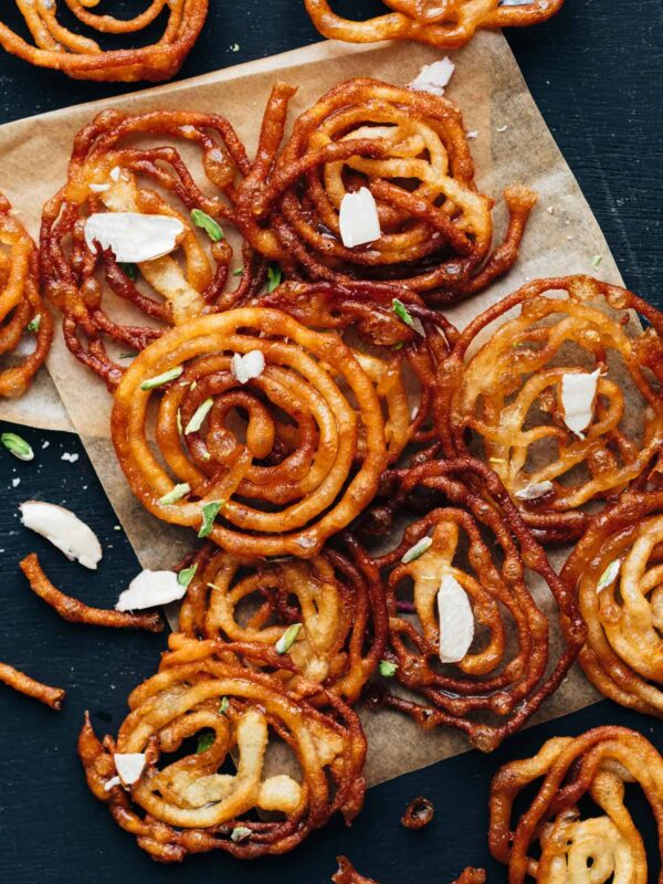 Overhead shot of crispy homemade jalebis with almond flakes sprinkled on top