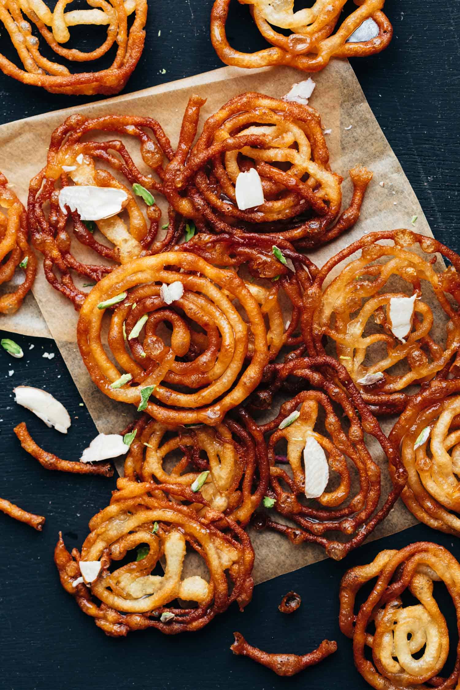 Overhead shot of crispy homemade jalebis with almond flakes sprinkled on top