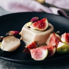 Masala Chai Panna Cotta served on a black plate with fresh figs