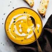 Creamy roasted pumpkin soup in a trencher with cheesy bread