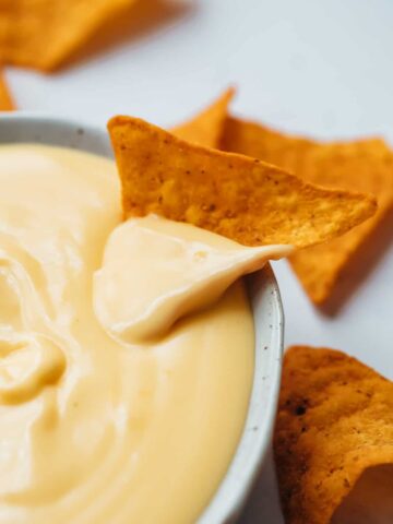 Nacho dipped in spicy nacho cheese sauce