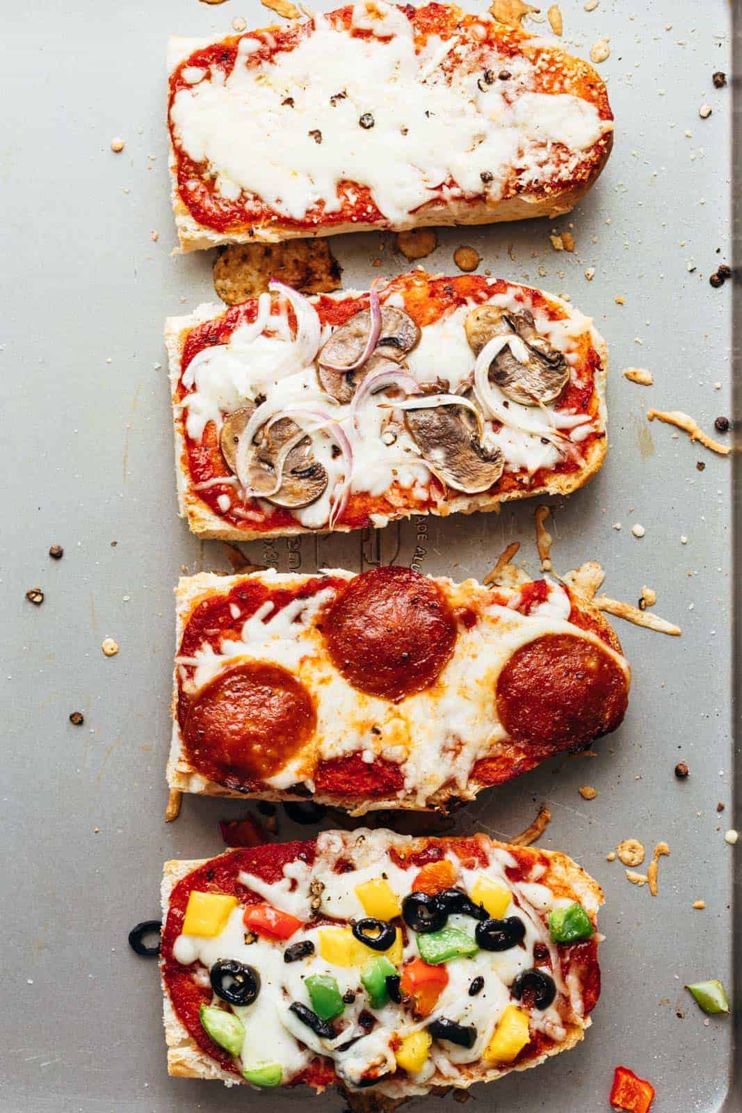 Toasted french bread pizza toasts straight from the oven on a baking sheet