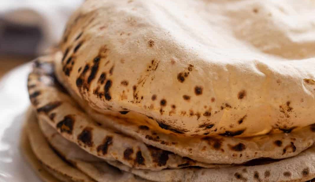 Soft puffy rotis stacked on a plate