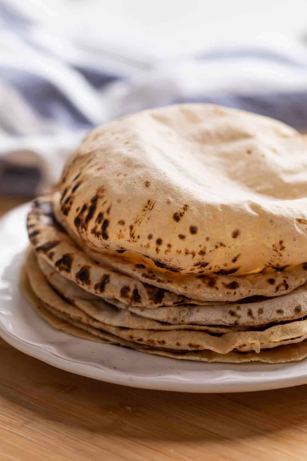 Soft puffy rotis stacked on a plate