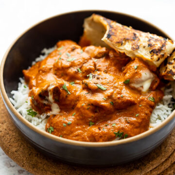 Butter Chicken served in a bowl with rice and naan bread