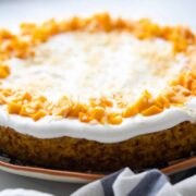 Eggless Mango cake topped with whipped cream and fresh mangoes and served on a platter