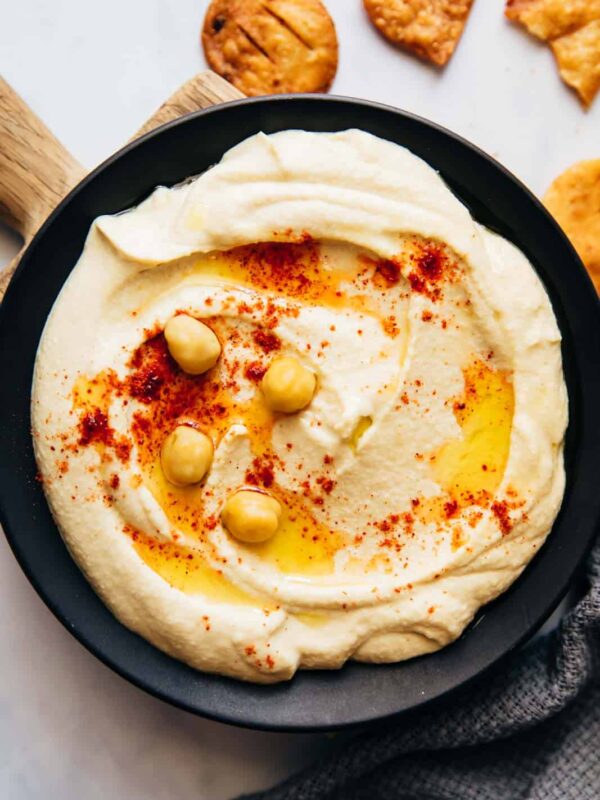 Hummus served on a plate with fried pita, olive oil and chickpeas