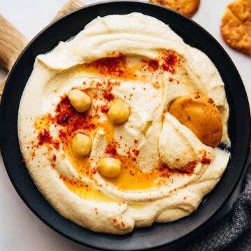Hummus served on a plate with fried pita, olive oil and chickpeas