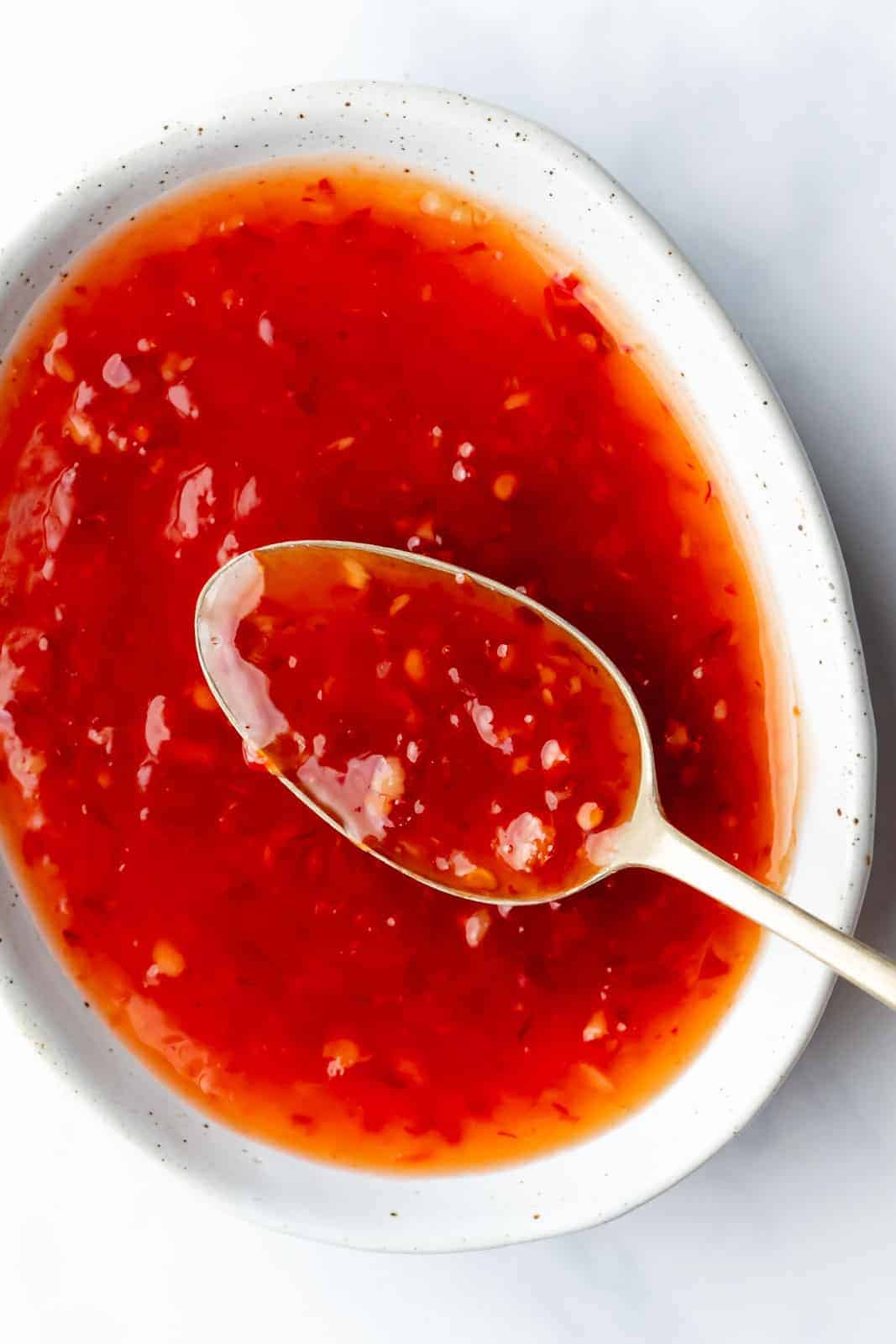 Thai sweet chili sauce served in a bowl with a spoon in it