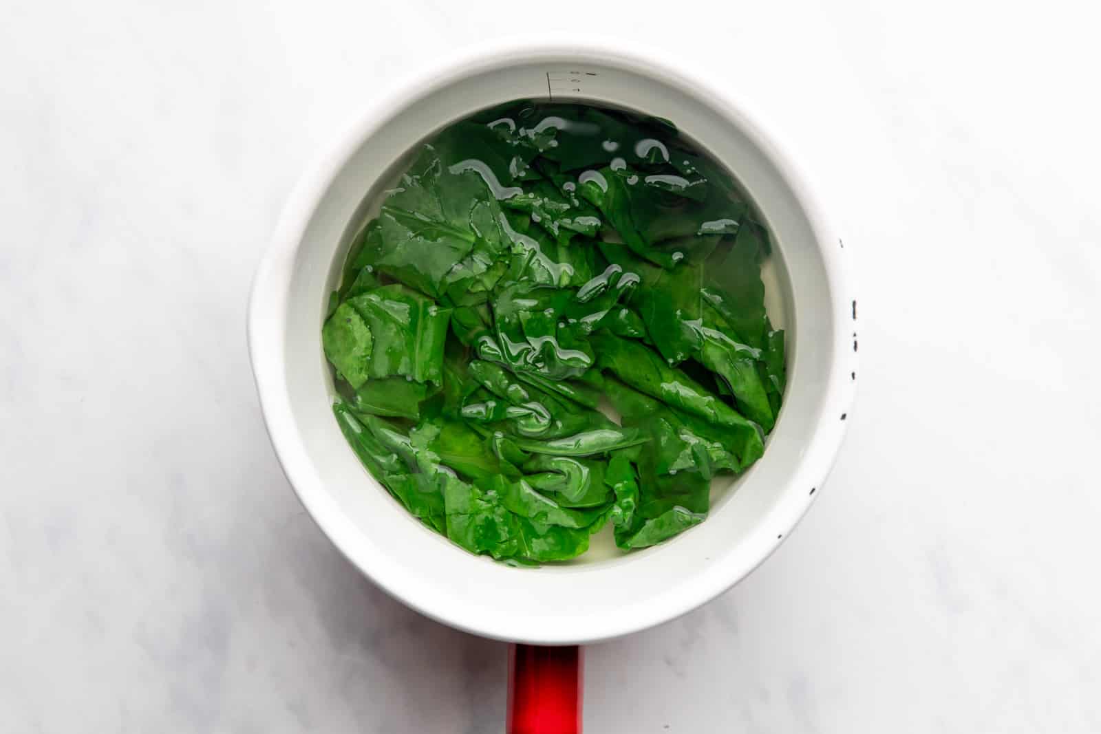 Spinach blanched in hot water in a saucepan