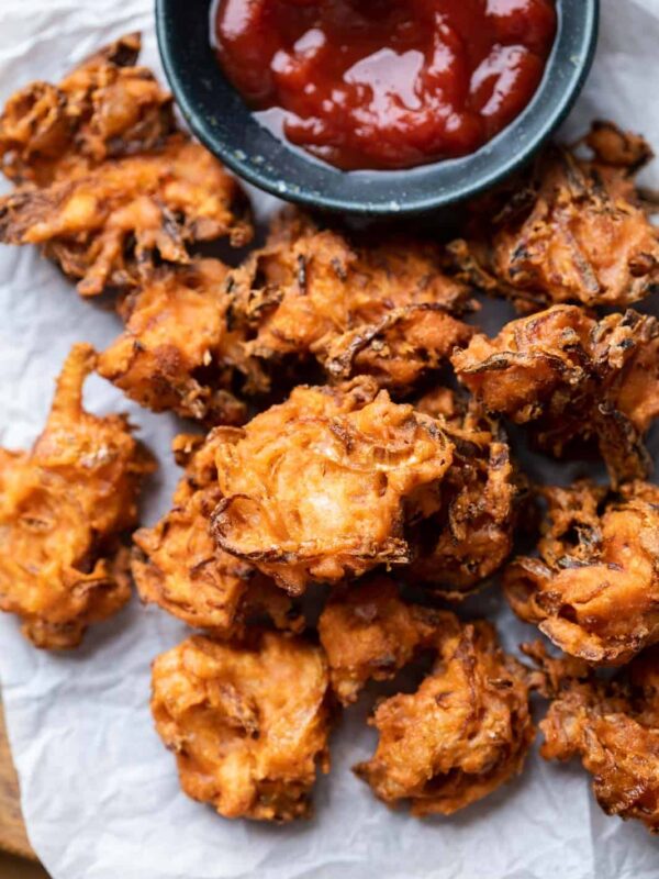 Onion Pakodas served on a platter with ketchup
