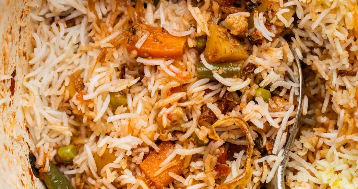 Closeup of veg biryani in the pot after a few spoonfuls have been served
