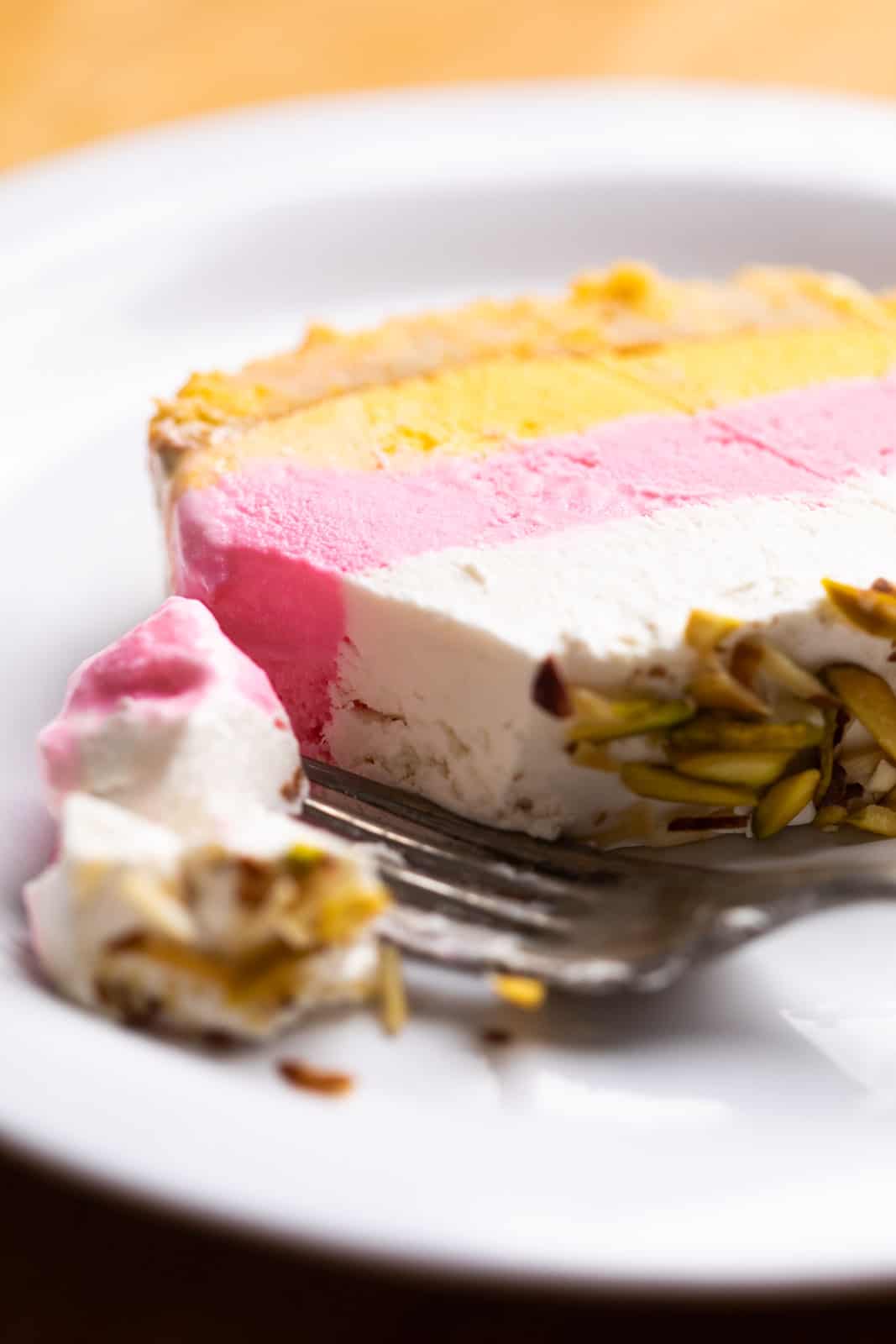 Closeup of a bite takes out of the classic cassata with cheesecake