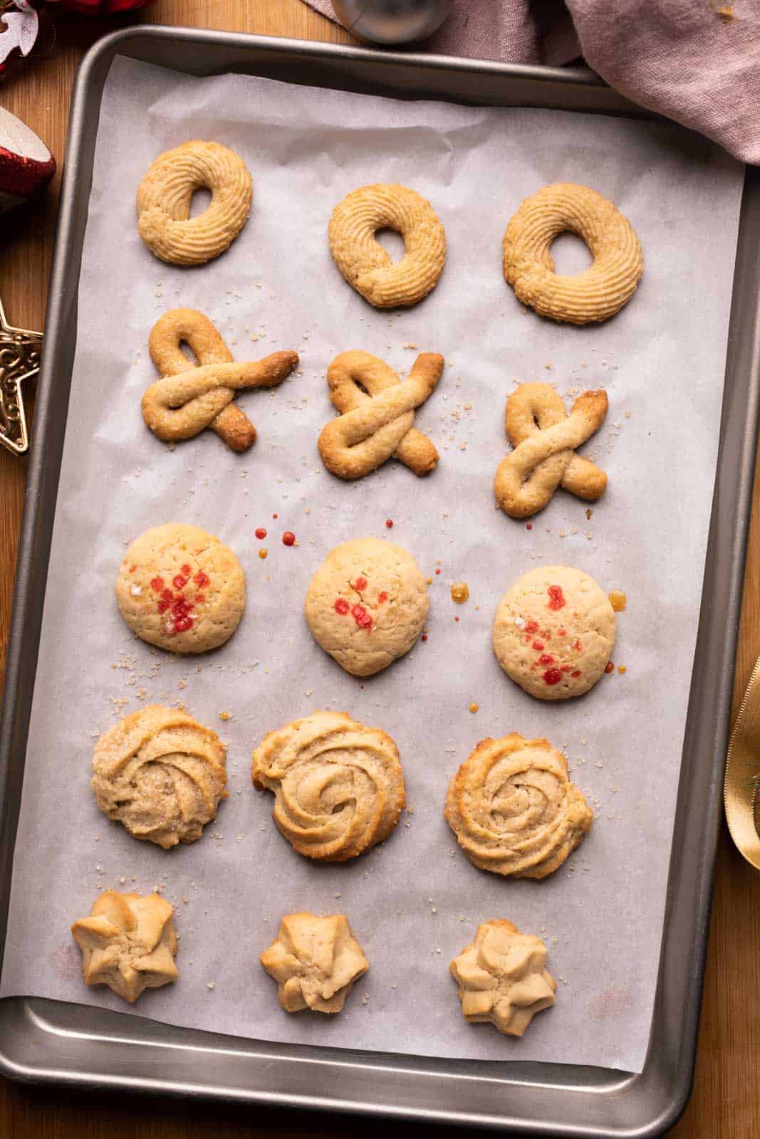 An entire baking tray full of danish brown butter cookies with five different cookie shapes