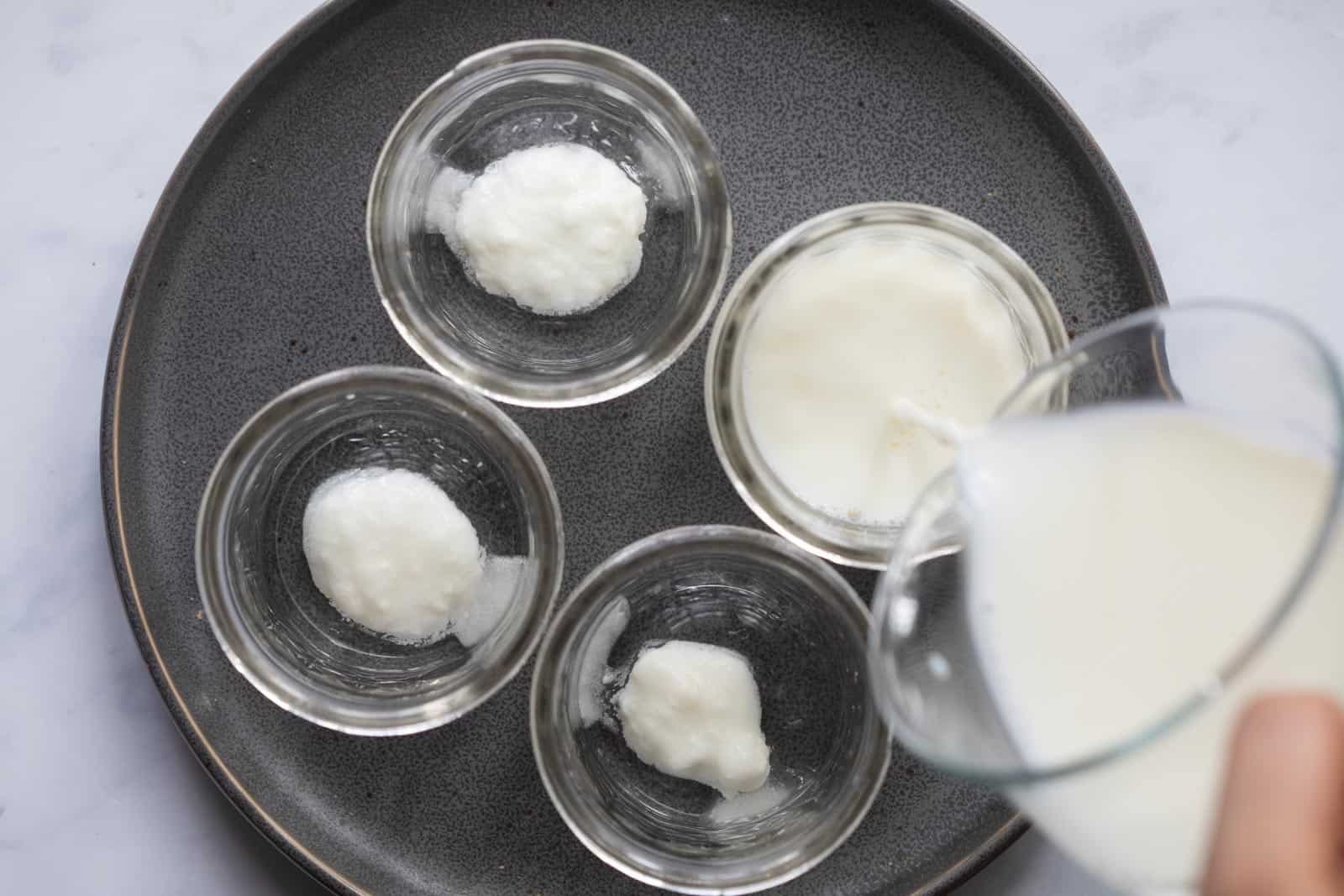 Milk being poured into mason jars to set yogurt