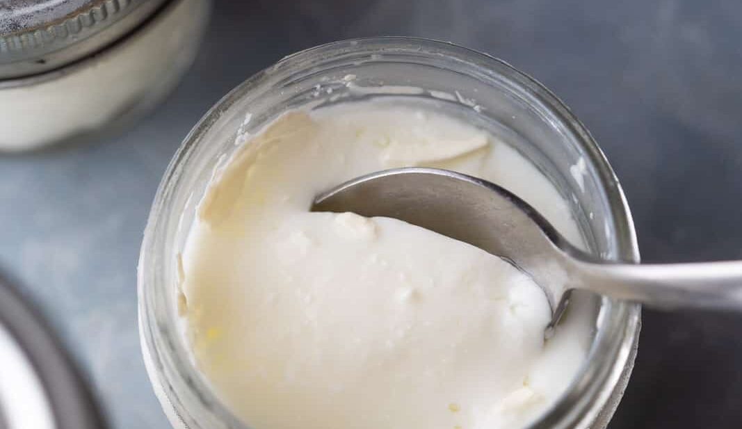 A spoon cutting into the yogurt to show the thick consistency of yogurt