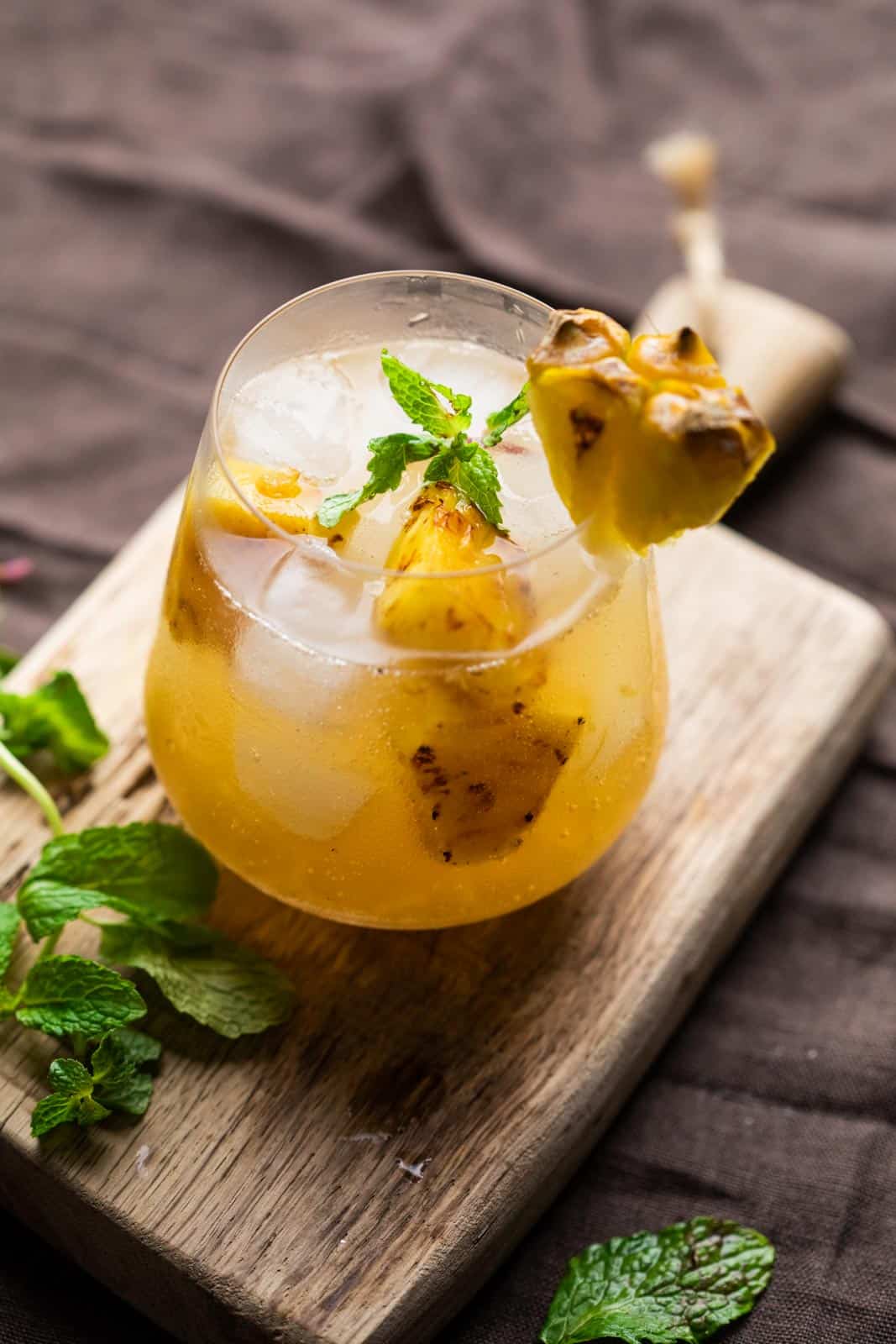 roasted pineapple moscow mule is a stemless wine glass with sprigs of mint