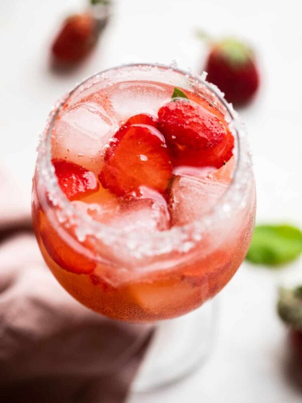 Strawberry Pepper Gin and Tonic served in a short stemmed glass with sugar on the rim
