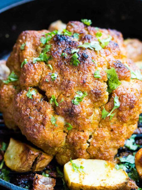 The tandoori cauliflower served with onions and potatoes in a skillet.