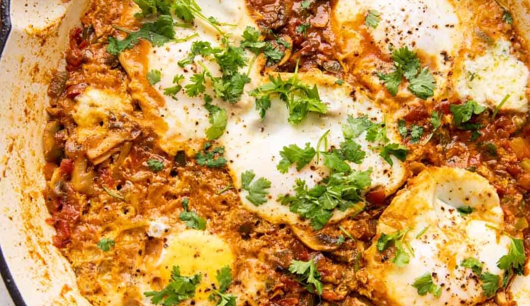 Masala shakshuka in a large pan served with toasted bread