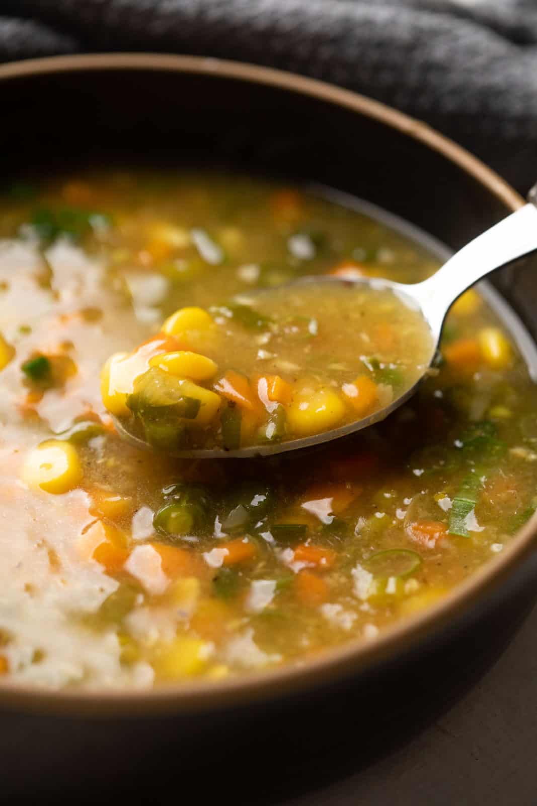 Closeup of a spoon of vegetarian sweet corn soup to show the creaminess and texture of the soup