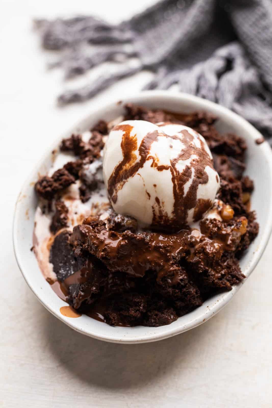 Eggless chocolate pudding cake served in a bowl with ice cream on top